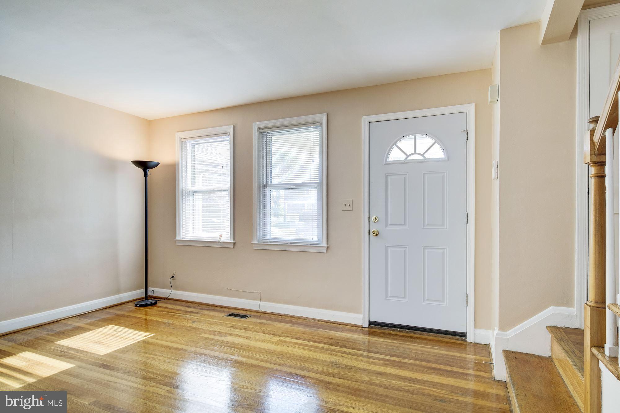 5902 Glenkirk Road Baltimore, MD 21239 - Photo 3 of 37 a view of empty room with wooden floor and fan