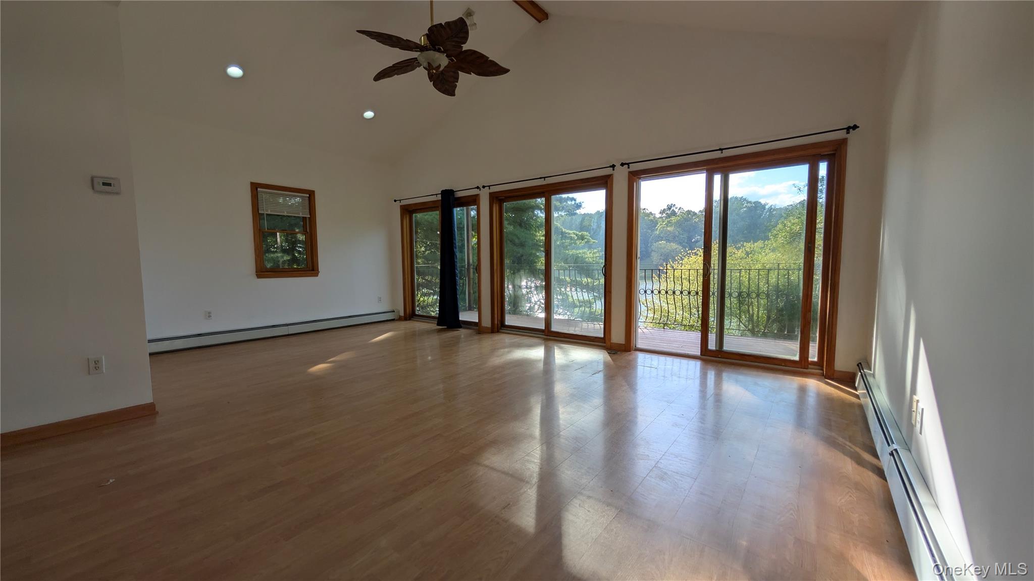 Unfurnished room featuring high vaulted ceiling, a baseboard radiator, recessed lighting, beam ceiling, and ceiling fan