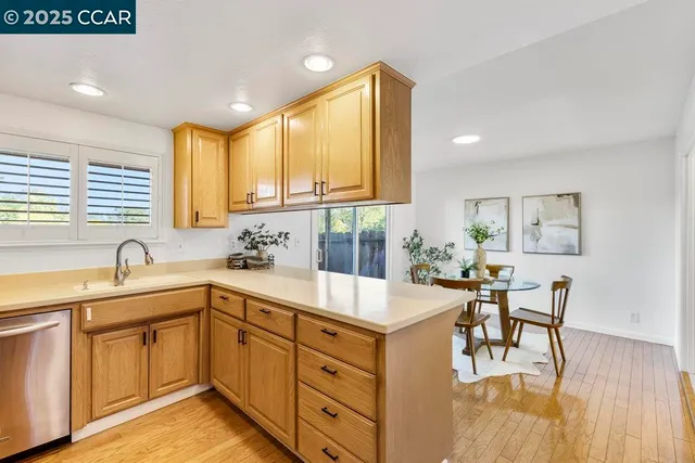a kitchen with a sink a counter top space and living room area