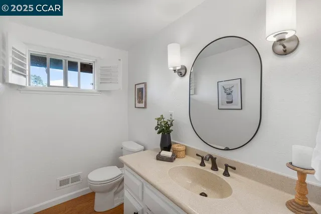 a bathroom with a toilet a sink and mirror