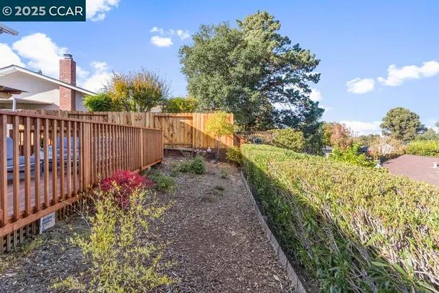 a view of flower garden with wooden fence