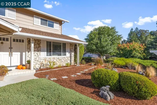 a view of a house with backyard and sitting area