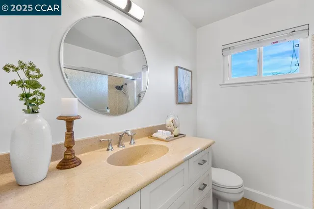 a bathroom with a granite countertop sink and a mirror