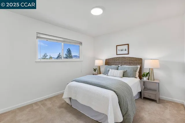 a bedroom with a bed and a painting on the wall