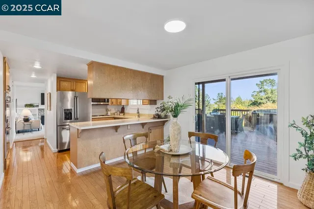 a dining room with stainless steel appliances kitchen island granite countertop a table and chairs in it
