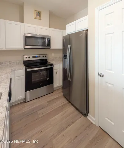 a kitchen with a refrigerator stove and microwave
