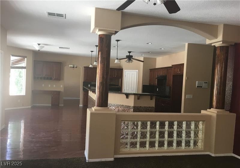 7414 Page Ranch Court Las Vegas, NV 89131 - Photo 11 of 36 Kitchen featuring ceiling fan, decorative columns, dark brown cabinetry, arched walkways, and recessed lighting