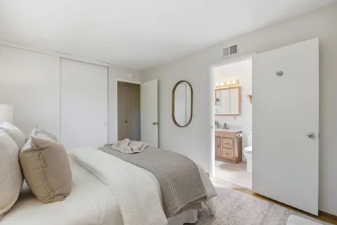 a bedroom with a bed a mirror and a window