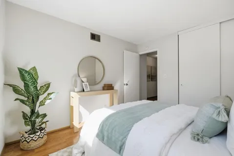 a bedroom with a bed and a potted plant