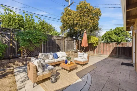 a view of backyard with outdoor seating and plants