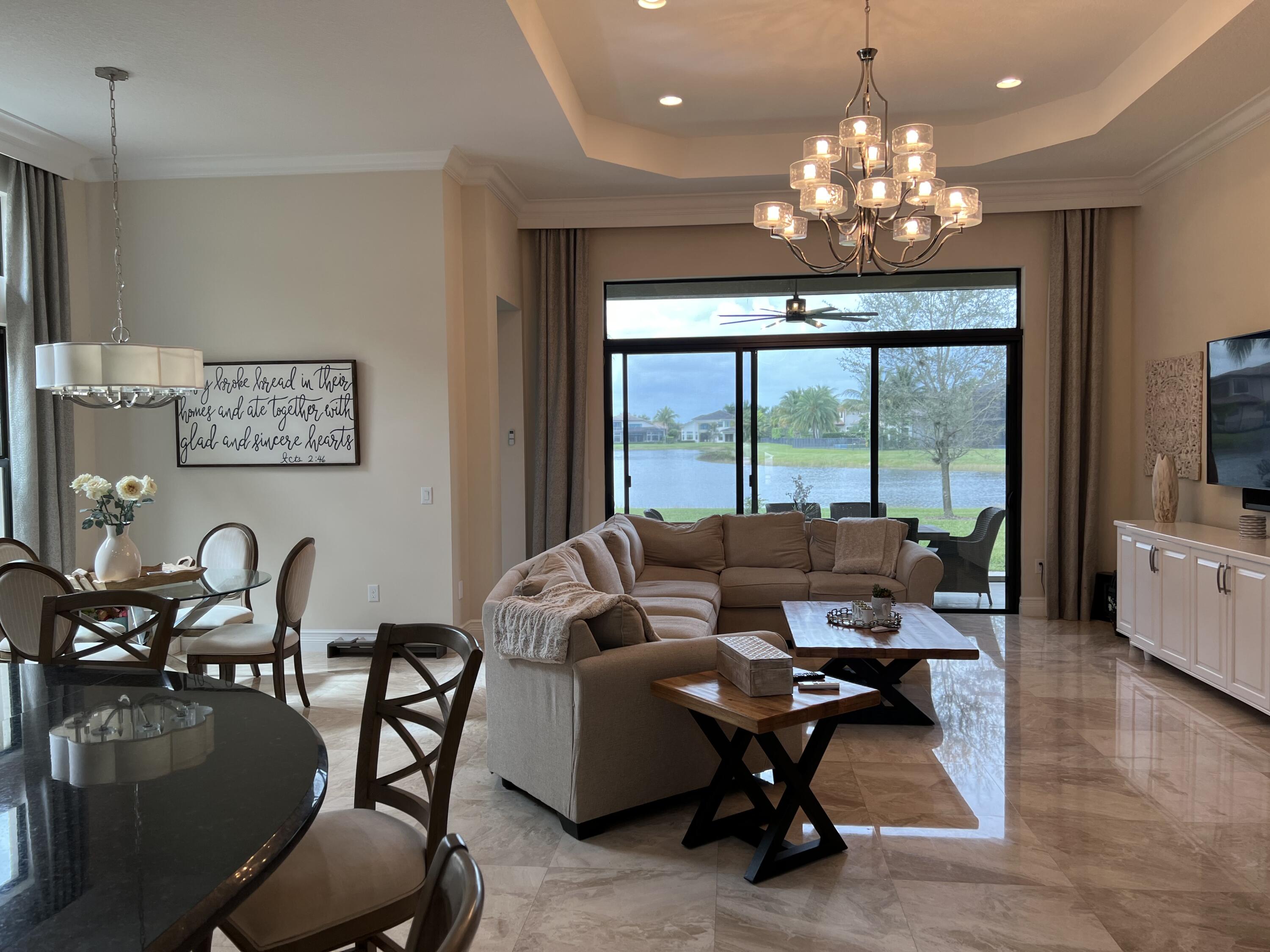 16831 Pavilion Way Delray Beach, FL 33446 - Photo 11 of 26 a living room with furniture chandelier and a large window