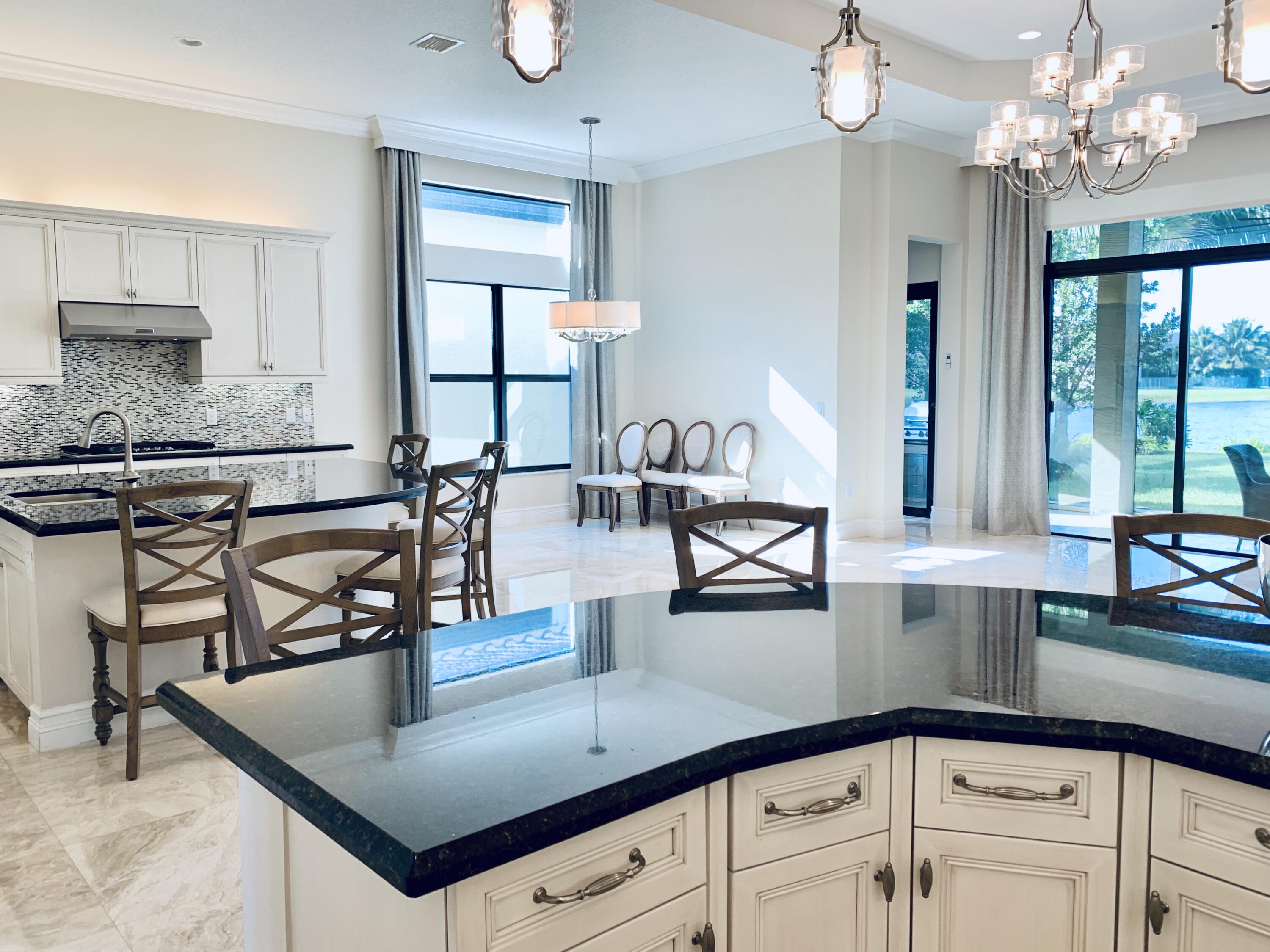 16831 Pavilion Way Delray Beach, FL 33446 - Photo 9 of 26 a kitchen with kitchen island granite countertop a stove a sink and a granite counter tops