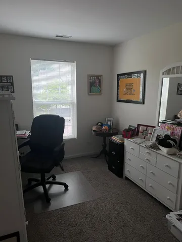 a view of a workspace with furniture and a window