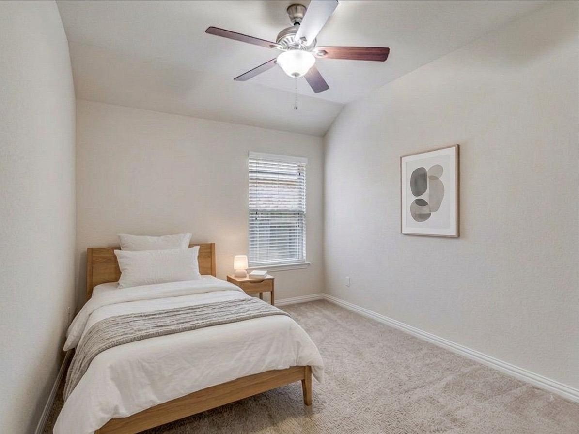 22005 Rhiannon Lane Pflugerville, TX 78660 - Photo 10 of 21 a bedroom with a large bed and a ceiling fan