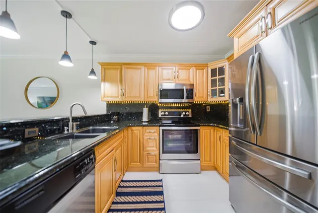 a kitchen with stainless steel appliances granite countertop a sink a stove and a refrigerator