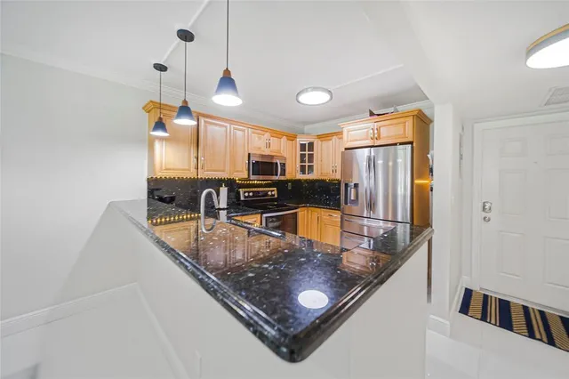 a kitchen with stainless steel appliances granite countertop a sink refrigerator and cabinets
