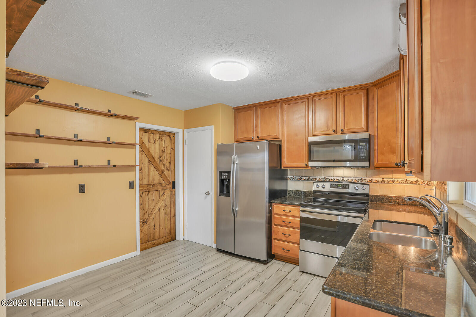 5814 Rover Drive Jacksonville, FL 32244 - Photo 17 of 30 a kitchen with granite countertop a refrigerator and a stove top oven