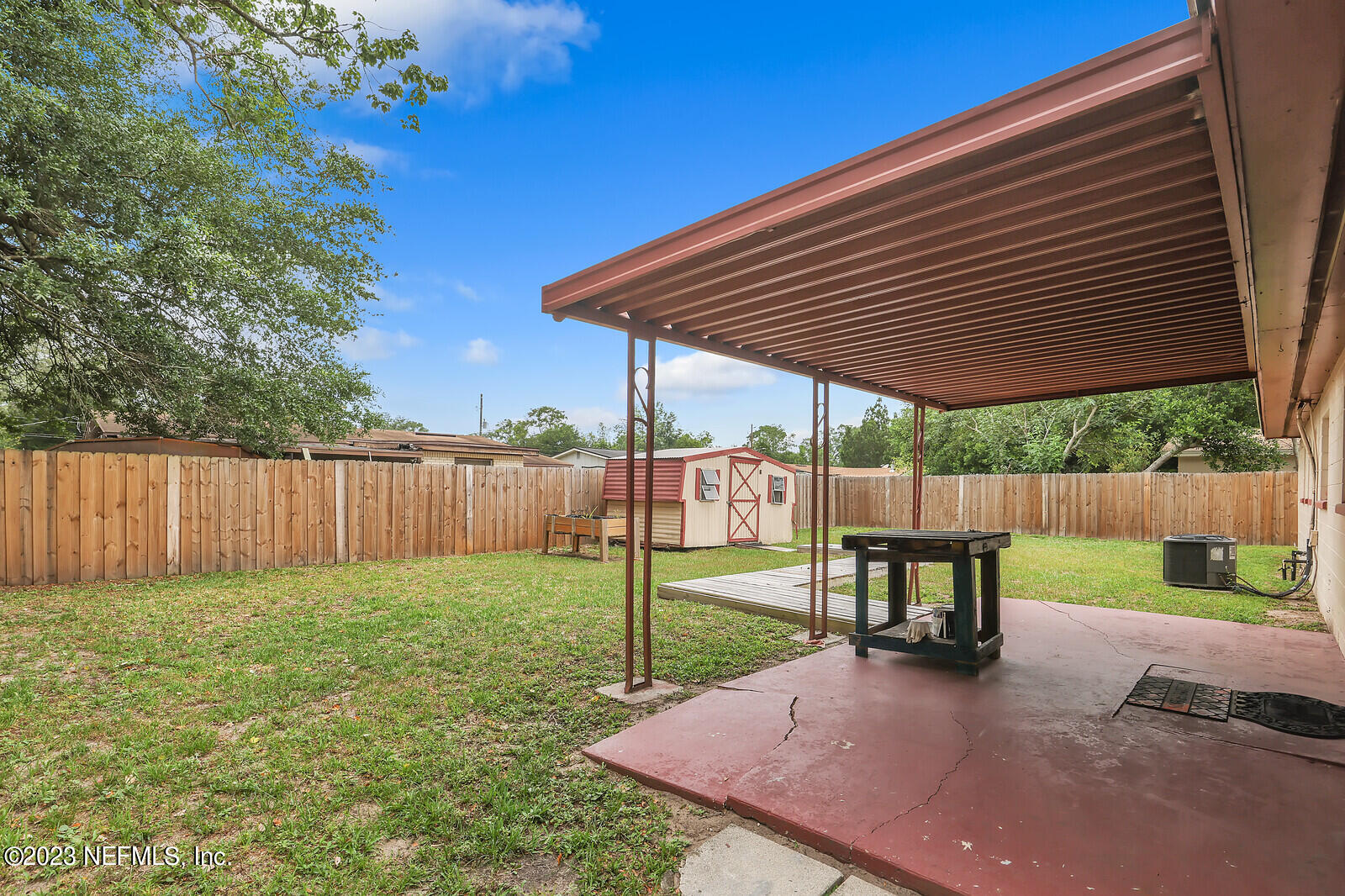 5814 Rover Drive Jacksonville, FL 32244 - Photo 24 of 30 a view of a backyard with table and chairs under an umbrella