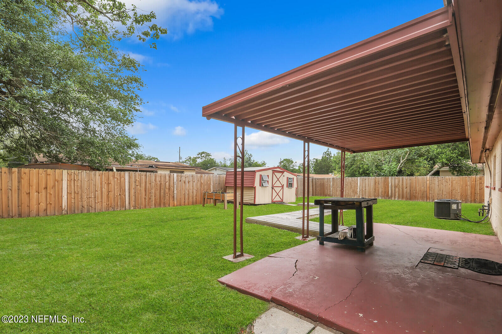 5814 Rover Drive Jacksonville, FL 32244 - Photo 3 of 30 a view of a backyard with table and chairs under an umbrella