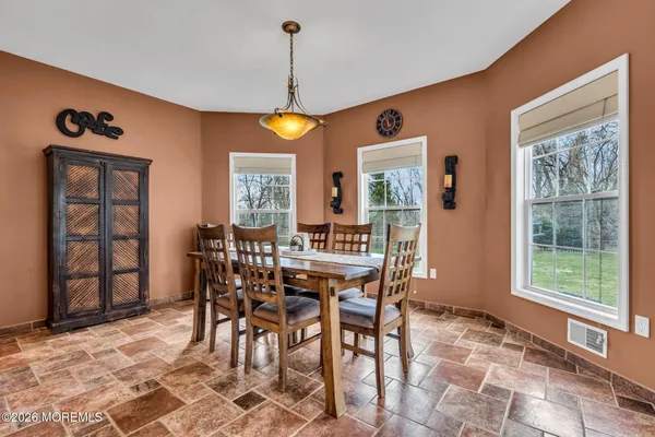 a front view of a house with a garden and trees