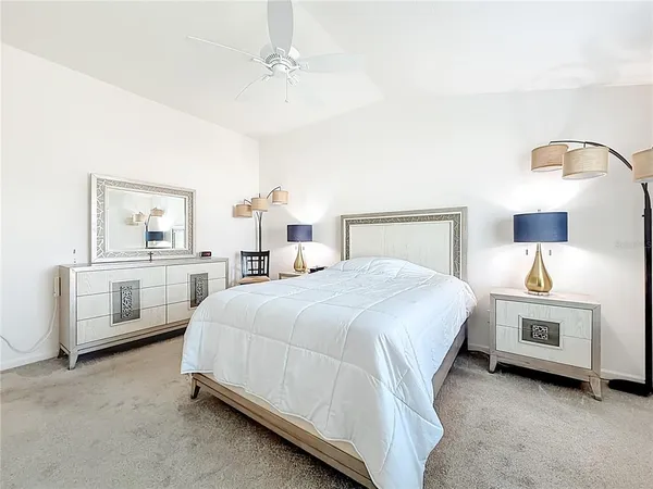 a spacious bedroom with a bed and a lamp