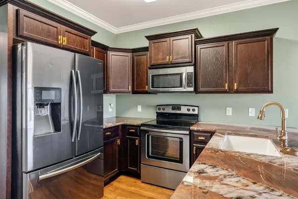 a kitchen with stainless steel appliances granite countertop a refrigerator stove and sink