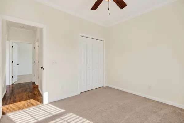 a room with a bed and a ceiling fan