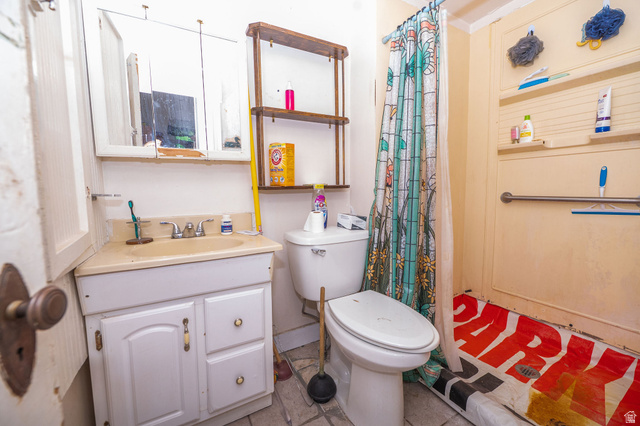 1256 24th Street Ogden, UT 84401 - Photo 12 of 34 Compact bathroom featuring a corner vanity with integrated sink, wall-mounted medicine cabinet, toilet, and shower area with grab bar