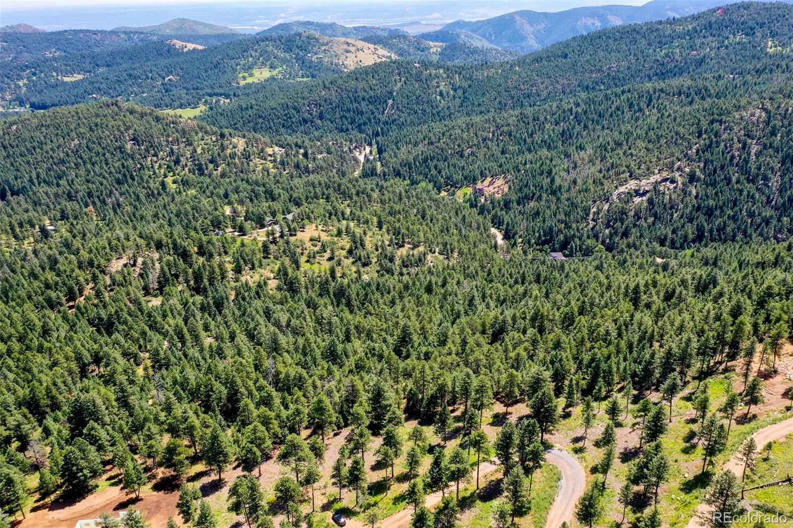 9206 Broken Bow Ranch Road Morrison, CO 80465 - Photo 15 of 15 a view of a green field with lots of bushes