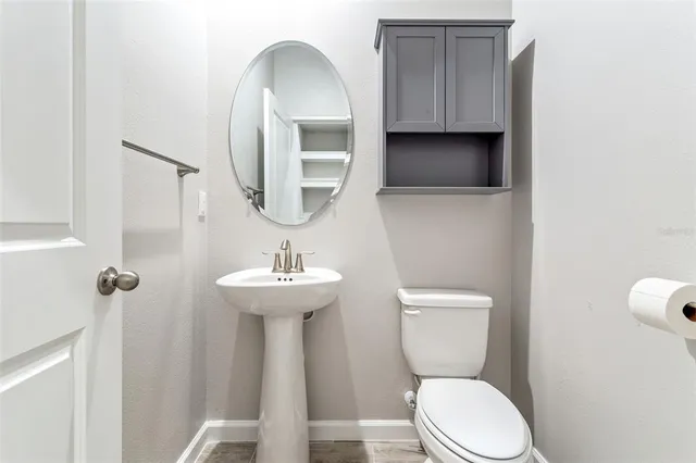 a bathroom with a toilet a sink and mirror