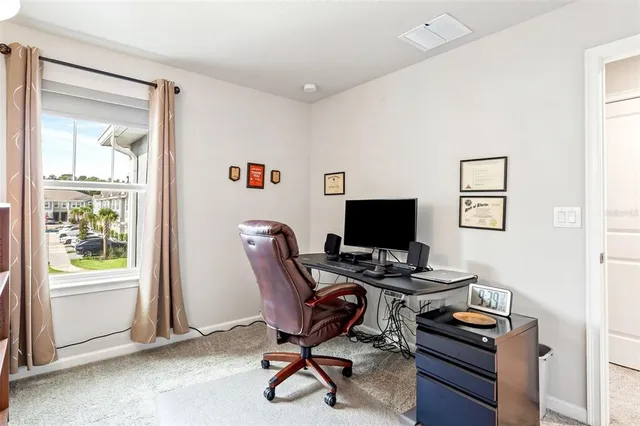 a view of a workspace with furniture and a window