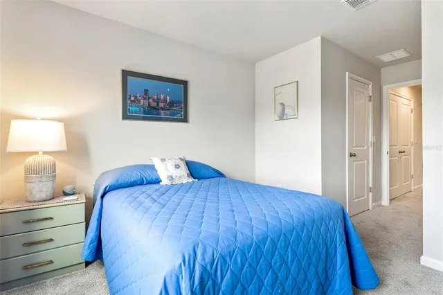 a bedroom with a bed and a lamp on dresser