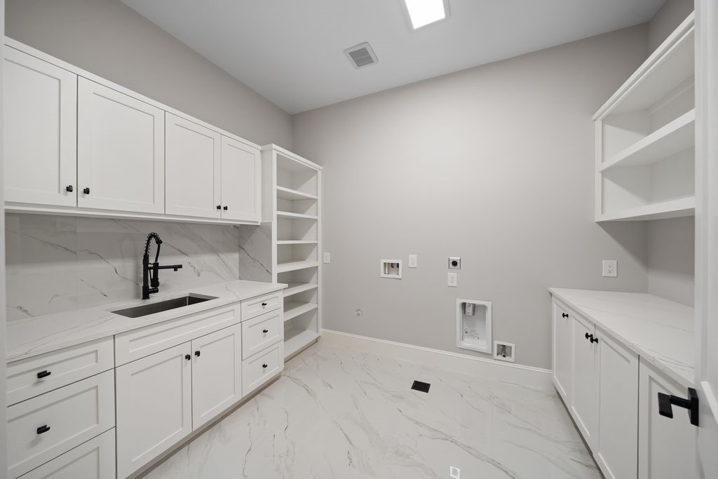 2046 MacArthur Street Houston, TX 77030 - Photo 30 of 39 Utility room with built-in cabinetry, quartz folding counter, and open shelving for organized storage and hanging space.