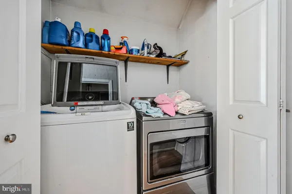 a utility room with dryer washer and a view of living area