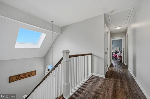 a view of a hallway with wooden floor and stairs