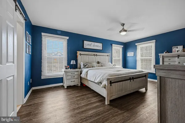 a bedroom with a large bed a chandelier and dresser