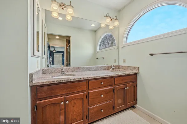 a bathroom with a granite countertop sink a large mirror and vanity