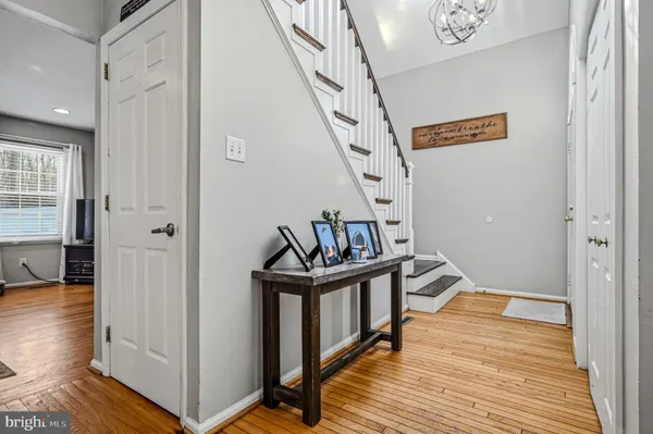 a view of a hallway with wooden floor and staircase