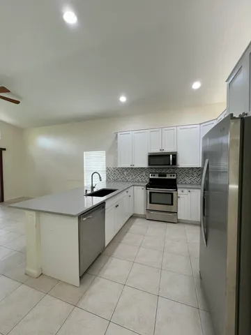 a kitchen with granite countertop a sink a stove and cabinets