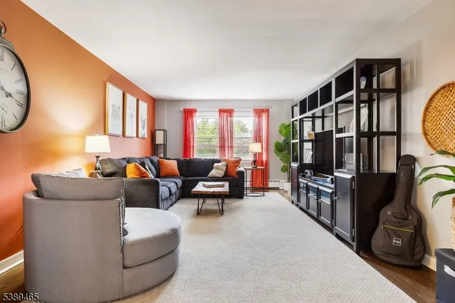 a living room with furniture a flat screen tv and a window