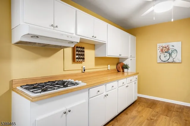 a kitchen with a stove and white cabinets