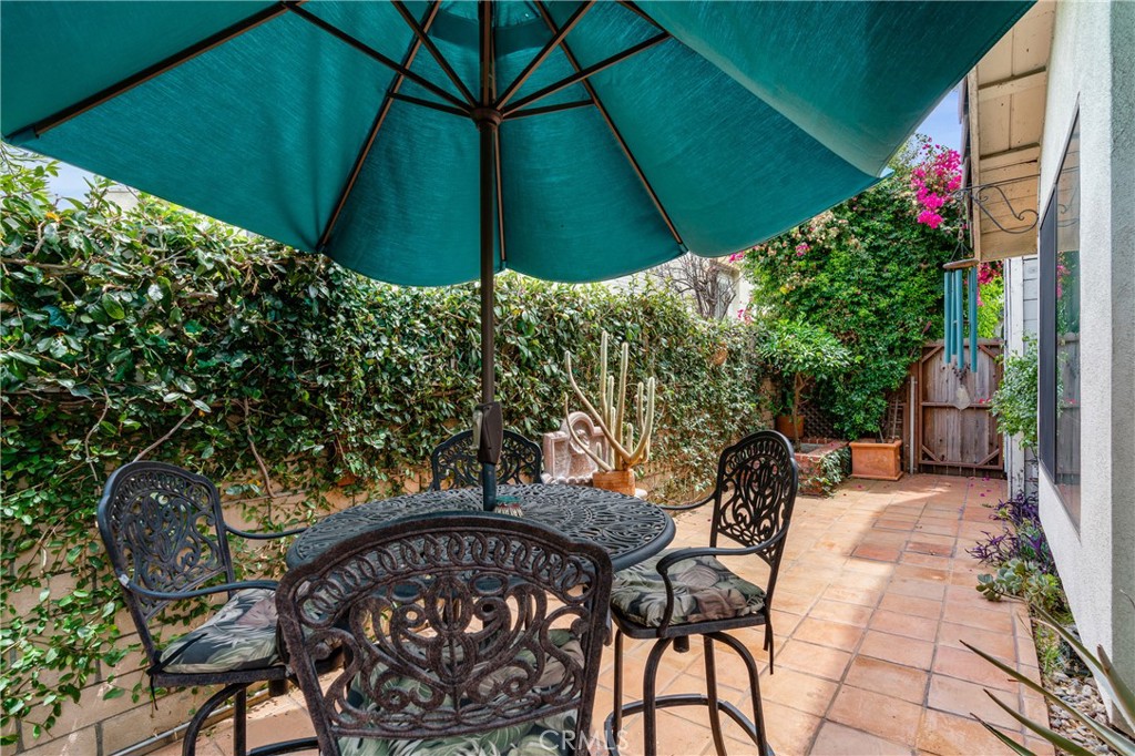 333 Genoa Street, Unit 6 Arcadia, CA 91006 - Photo 32 of 40 a backyard of a house with table and chairs under an umbrella