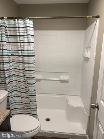 a bathroom with a toilet and a shower curtain