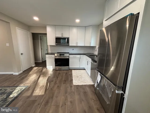 a kitchen with stainless steel appliances a refrigerator a sink a stove top oven a refrigerator and cabinets