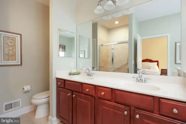 a bathroom with a granite countertop sink a toilet and a mirror