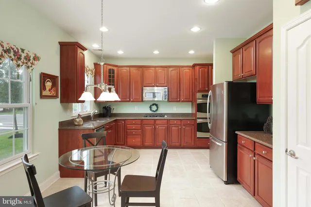 a kitchen with stainless steel appliances granite countertop wooden cabinets a stove top oven a sink and dishwasher