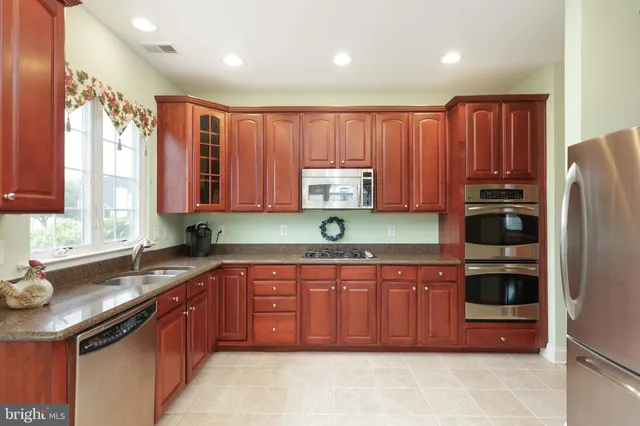 a kitchen with stainless steel appliances granite countertop a refrigerator and a sink