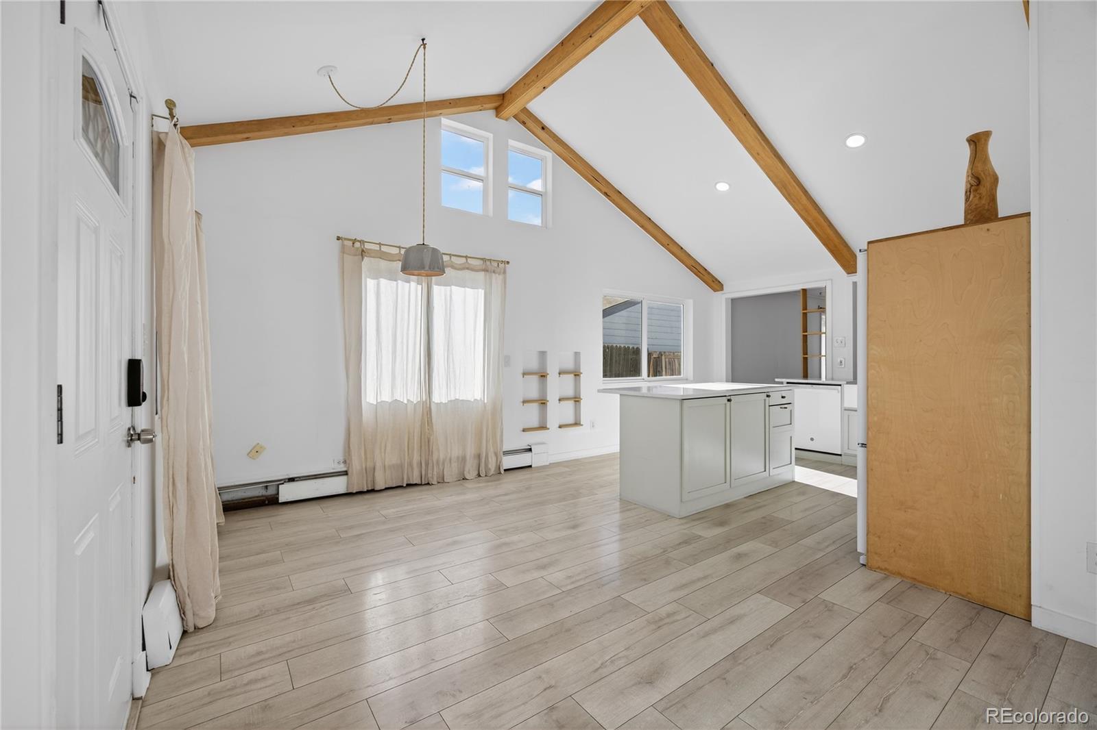 a view of a kitchen with wooden floor and a refrigerator