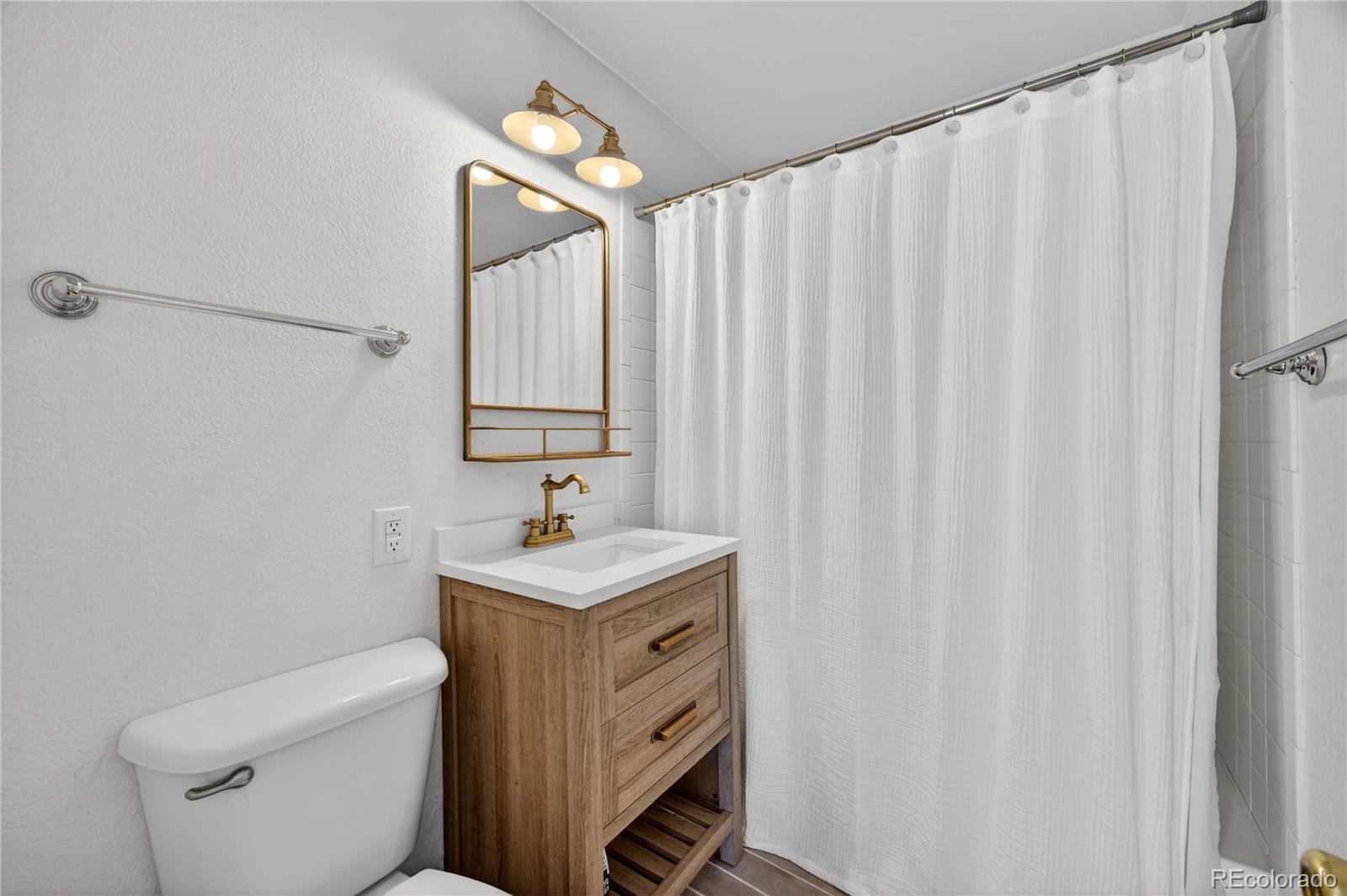 2375 Hanover Street Aurora, CO 80010 - Photo 12 of 36 a bathroom with a sink a toilet and a mirror