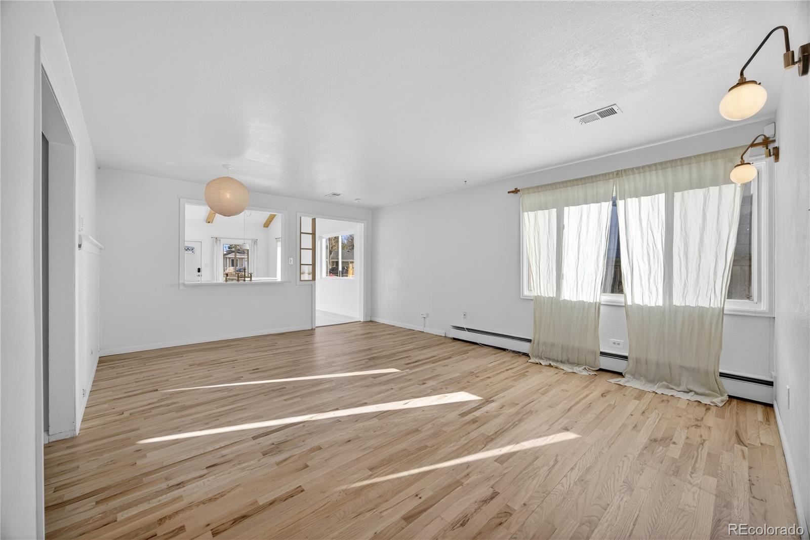 2375 Hanover Street Aurora, CO 80010 - Photo 15 of 36 a view of an empty room with a window and wooden floor